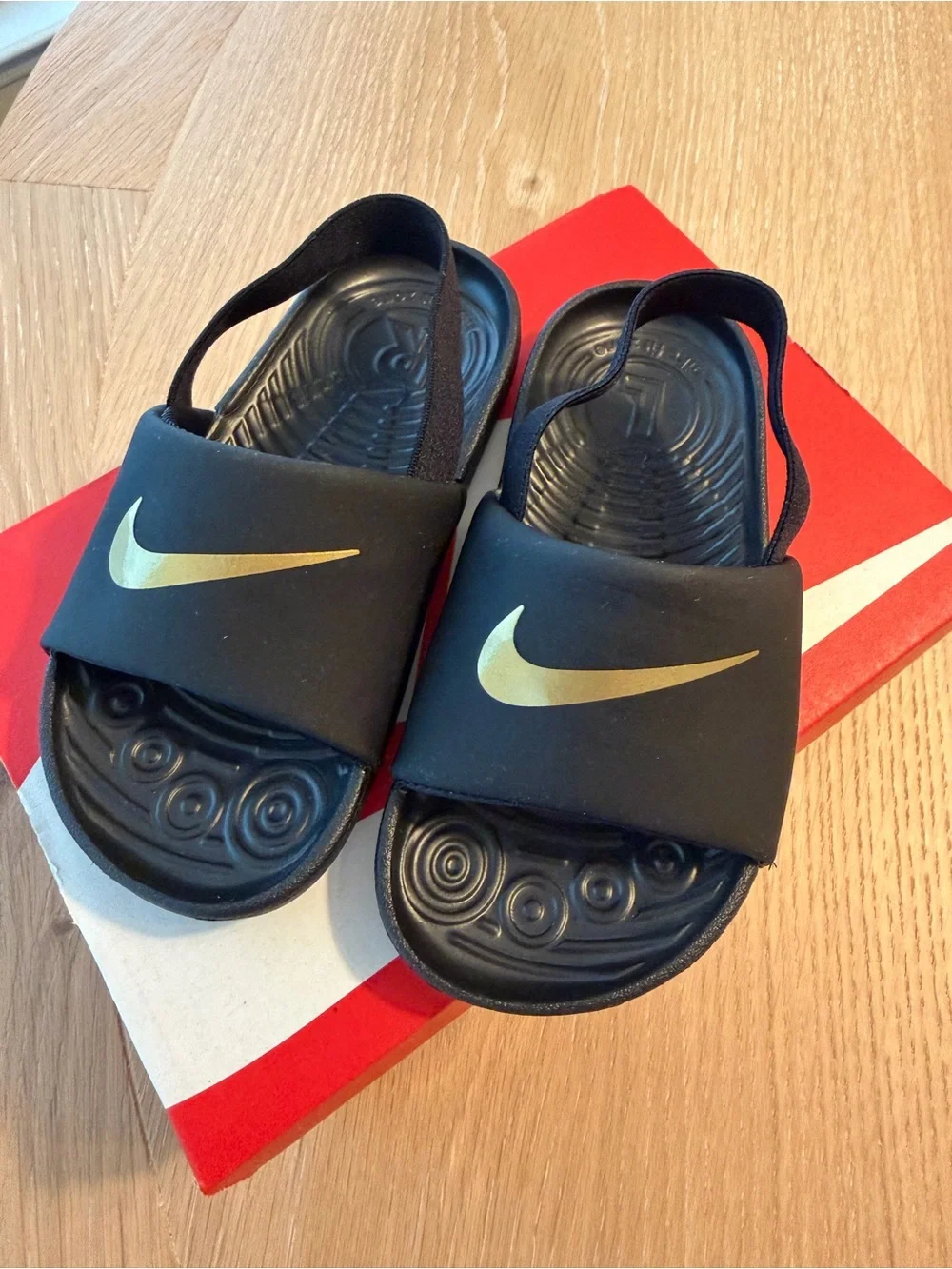 Nike Kids Black Slides with Gold Swoosh and Heel Strap